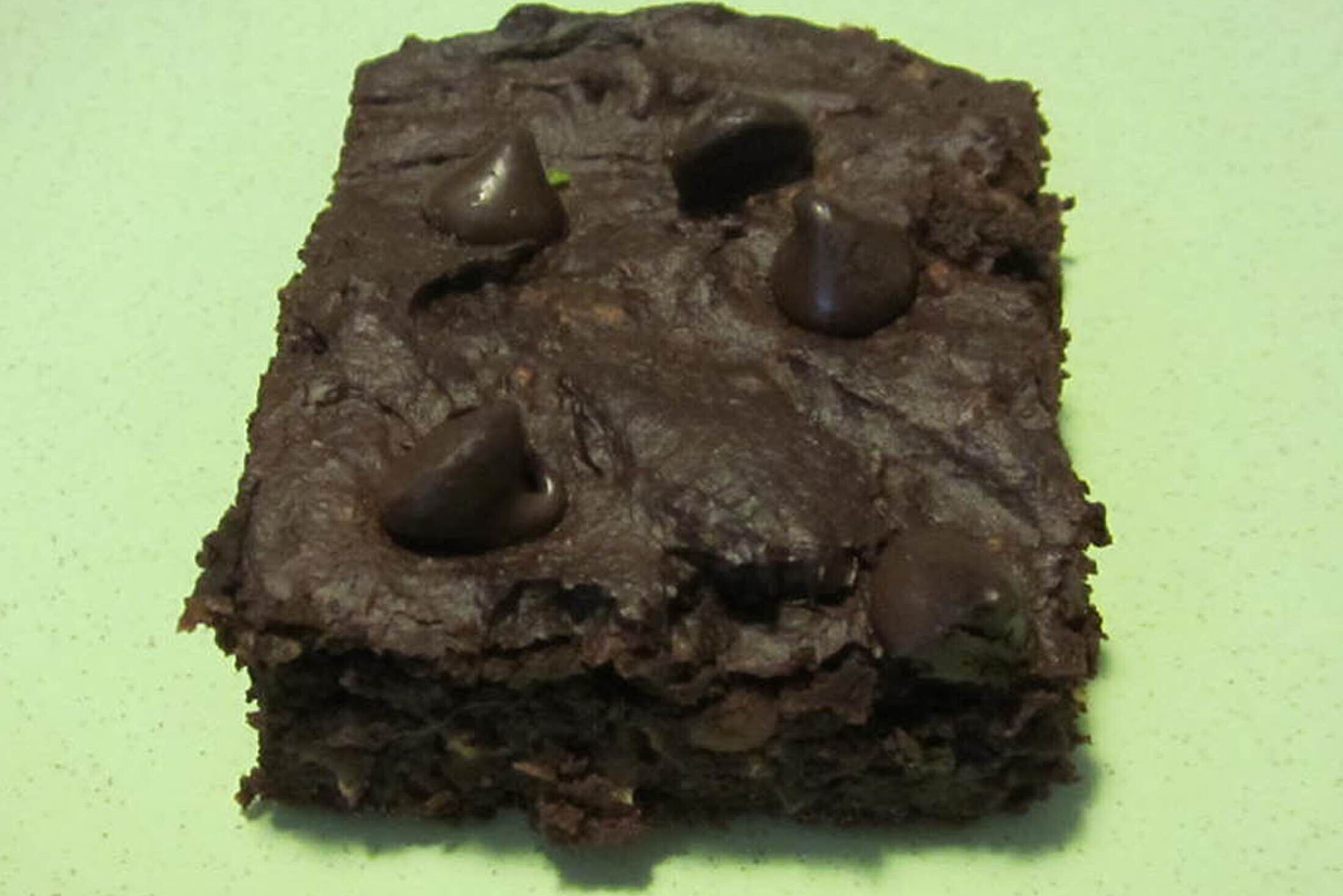 Chocolate chip brownie on a green plate