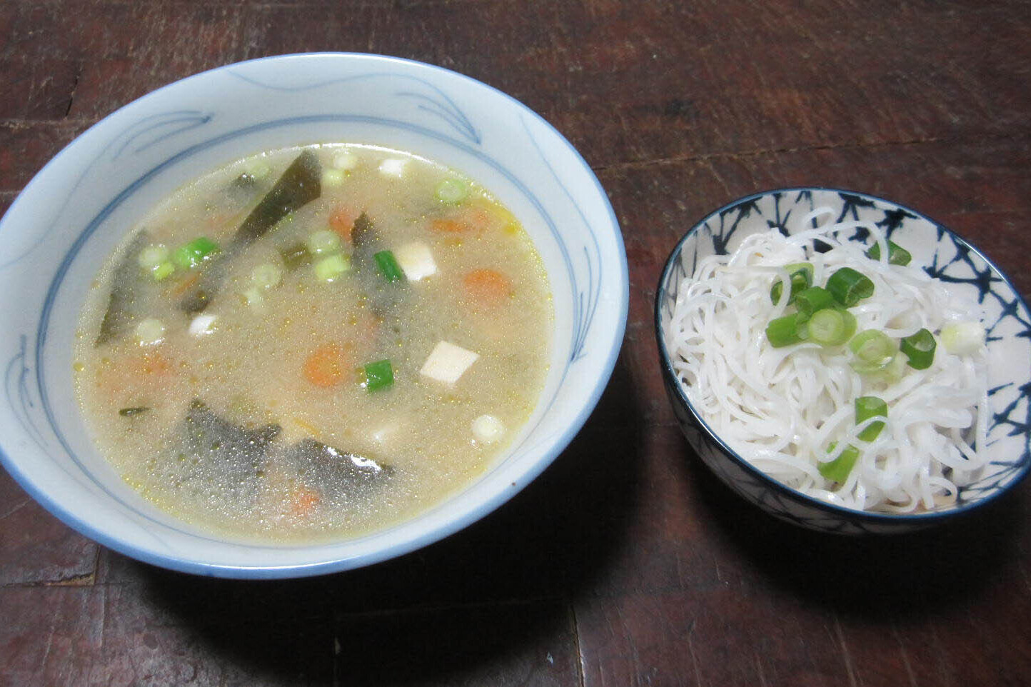 Bowl of miso soup with rice noodles on the side
