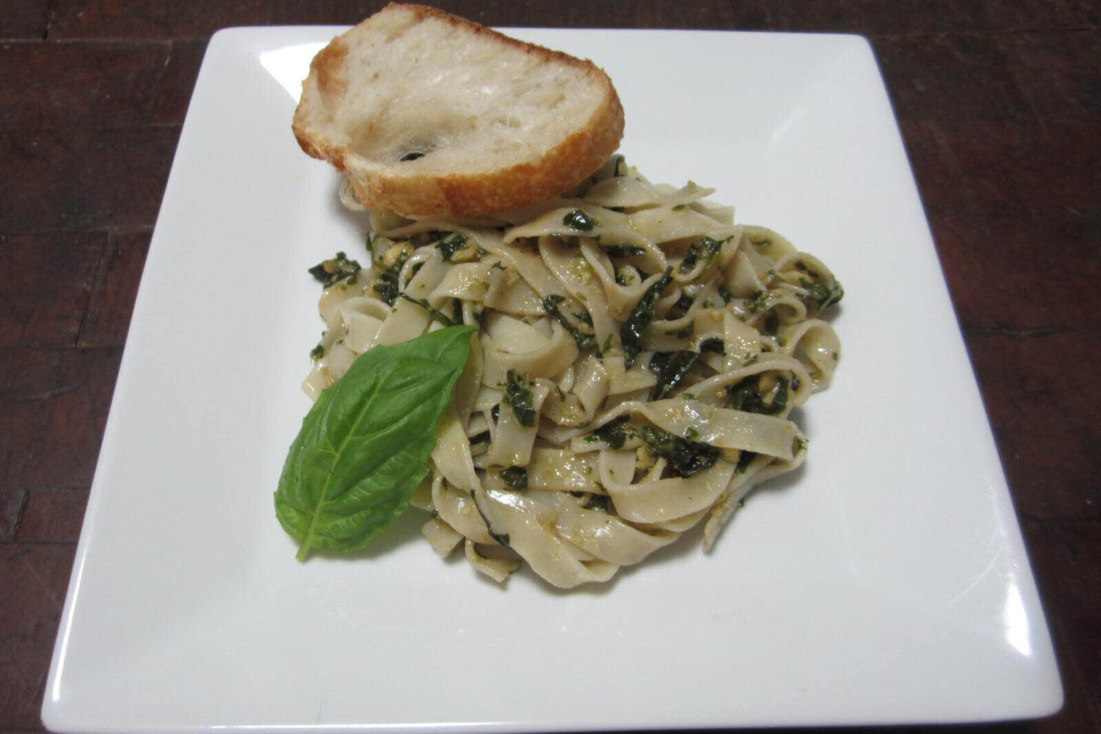 Pasta with pesto and a slice of bread