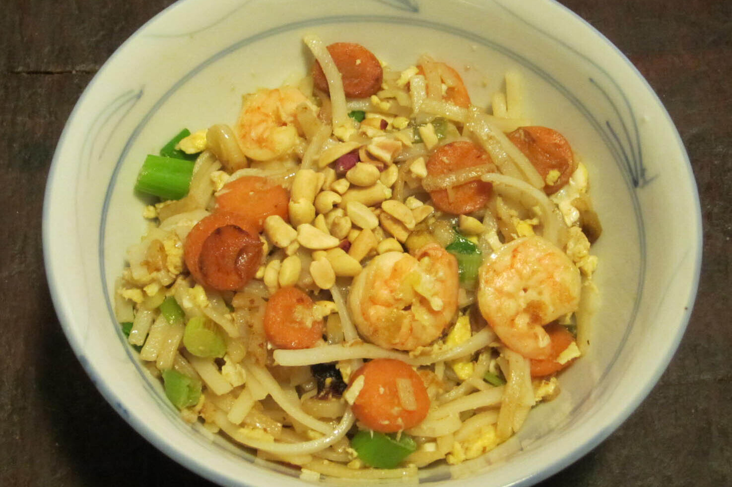 Rice noodles with shrimp, peanuts, carrots, and scallion