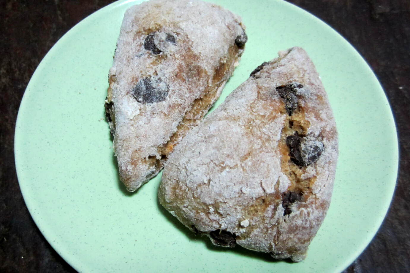 Two banana chocolate chip scones on a teal plate