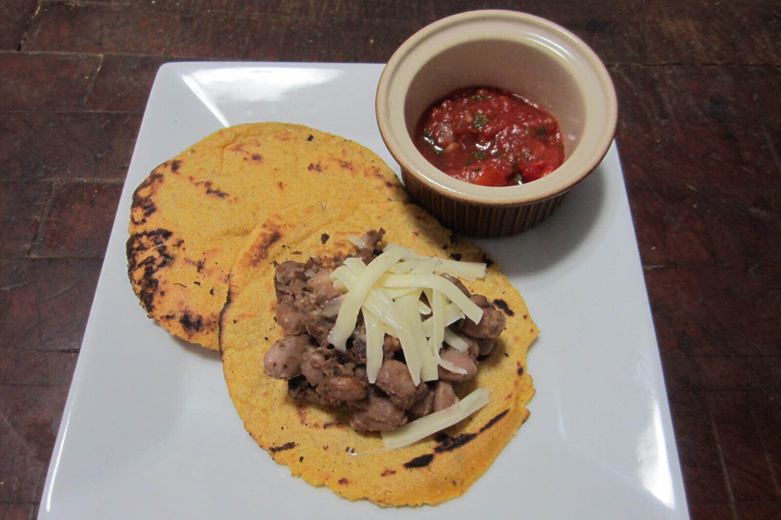 Tortillas with beans, cheese, and a side of tomato salsa