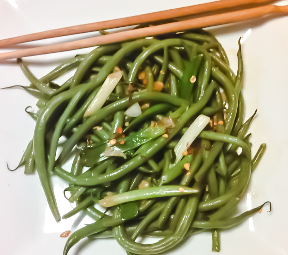Szechuan Green Bean Salad on white plate with chopsticks
